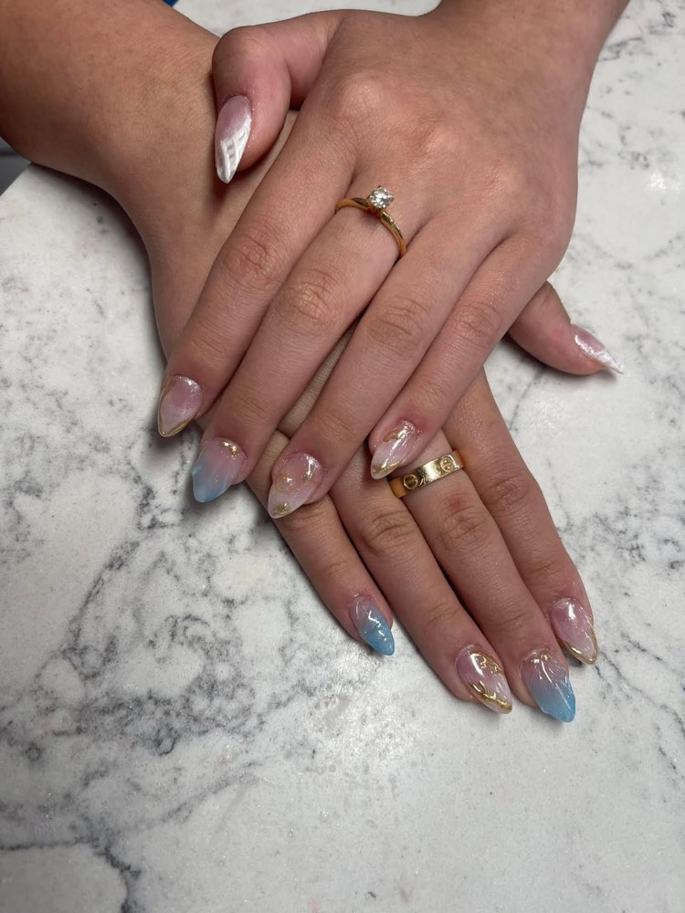 Soft aurora ombré nails in blush and baby blue with rose-gold foil, on white marble